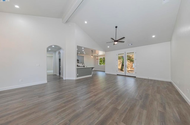 unfurnished living room with sink, dark hardwood / wood-style flooring, ceiling fan, beamed ceiling, and high vaulted ceiling