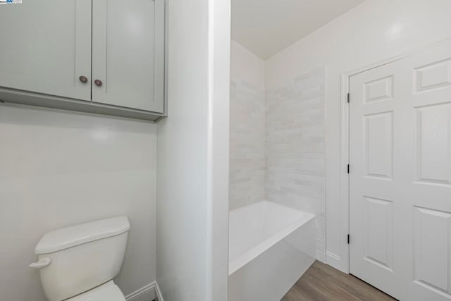 bathroom with hardwood / wood-style flooring and toilet