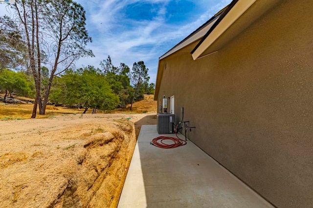 view of side of home featuring a patio area and central AC