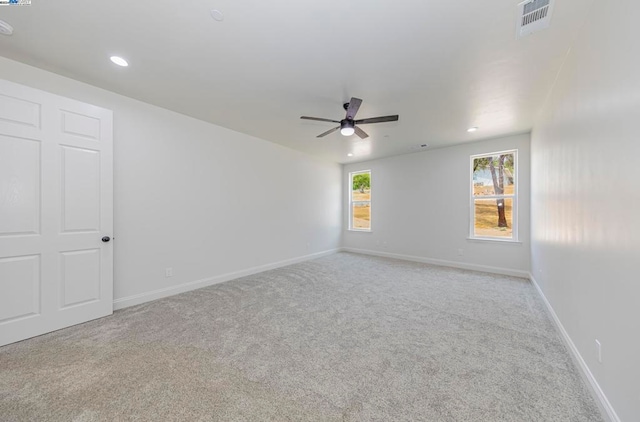 carpeted spare room with ceiling fan