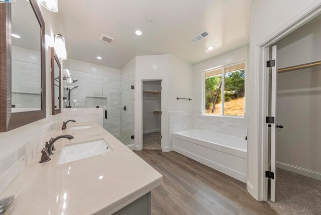 bathroom with vanity, hardwood / wood-style floors, and separate shower and tub