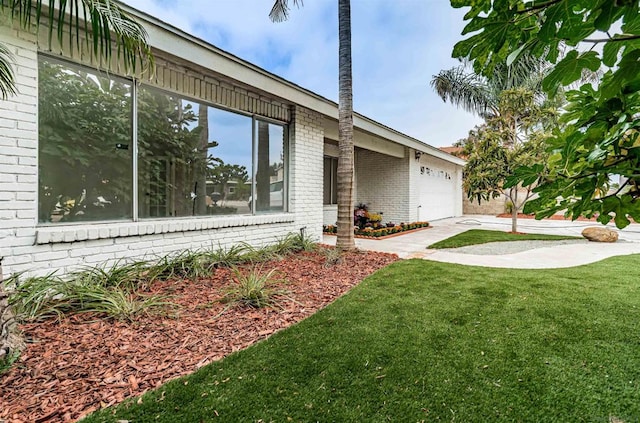 view of side of home featuring a yard and a garage