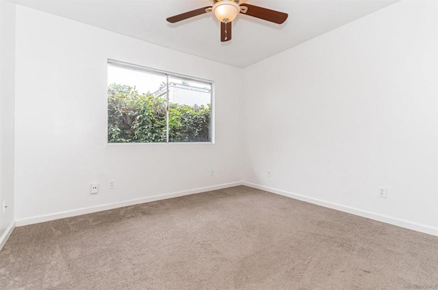 carpeted spare room featuring ceiling fan