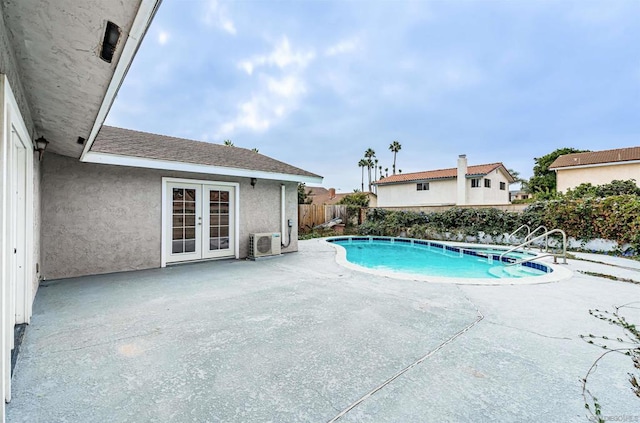 view of swimming pool with french doors and a patio