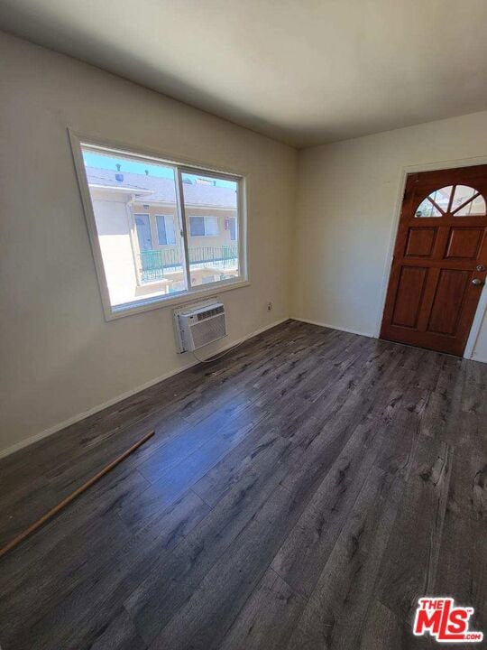 foyer with a wall unit AC and dark wood-type flooring