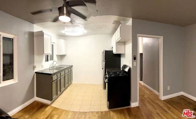 kitchen featuring white cabinetry, light hardwood / wood-style flooring, black gas stove, and sink