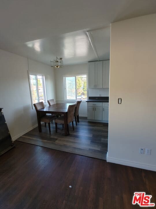 dining room featuring a notable chandelier and dark wood-type flooring