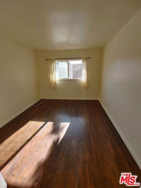 empty room with dark hardwood / wood-style flooring