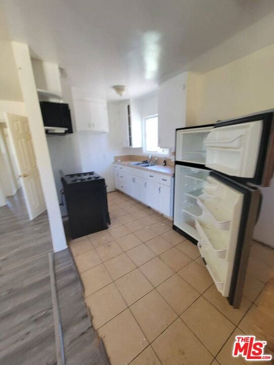 kitchen with white cabinets, white fridge, and sink