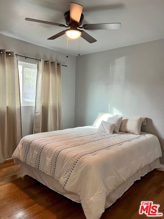 bedroom with ceiling fan and dark hardwood / wood-style flooring