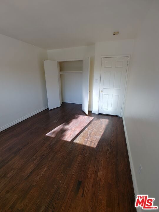 unfurnished room featuring dark wood-type flooring