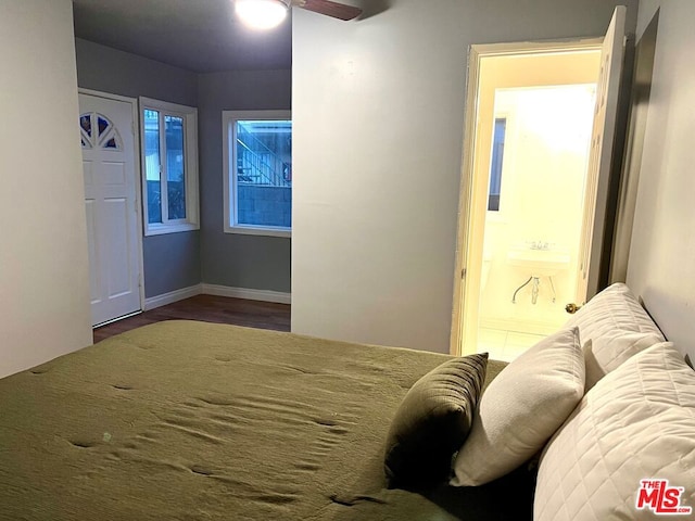 bedroom with connected bathroom, ceiling fan, dark wood-type flooring, and sink