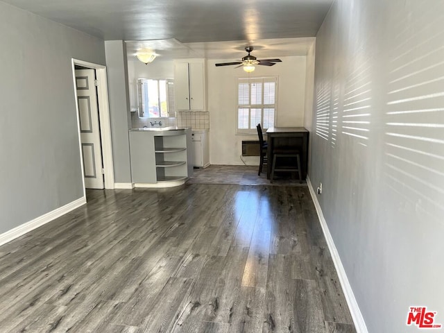 unfurnished living room featuring dark hardwood / wood-style flooring, ceiling fan, and plenty of natural light