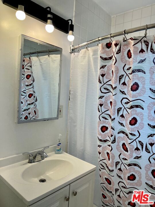 bathroom featuring vanity and curtained shower