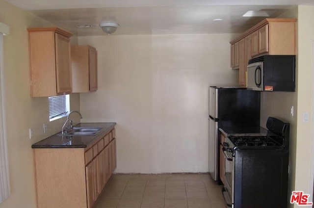 kitchen with light tile patterned floors, stainless steel appliances, light brown cabinetry, and sink