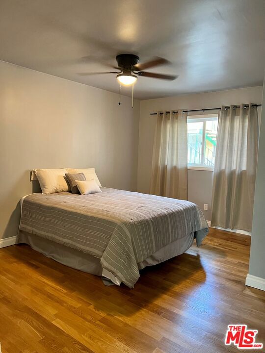 bedroom with wood-type flooring and ceiling fan