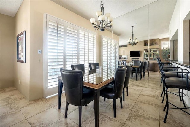 dining space with a notable chandelier, a healthy amount of sunlight, and lofted ceiling