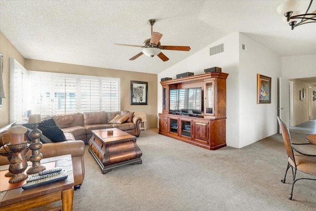 living room with lofted ceiling, light carpet, a textured ceiling, and ceiling fan