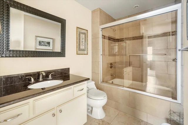 full bathroom featuring vanity, enclosed tub / shower combo, toilet, and tile patterned flooring