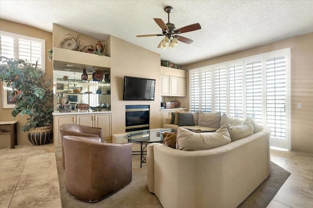 tiled living room featuring a textured ceiling and ceiling fan