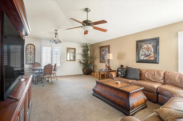 living room with a textured ceiling, carpet flooring, lofted ceiling, and ceiling fan with notable chandelier