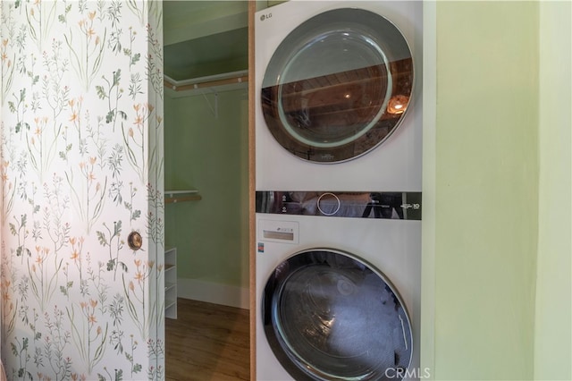 clothes washing area with stacked washer and clothes dryer and hardwood / wood-style floors