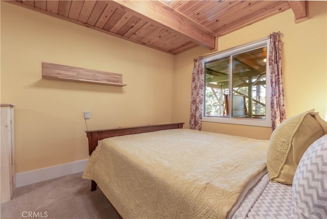 bedroom with beamed ceiling, carpet floors, and wooden ceiling