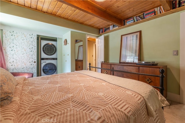 carpeted bedroom featuring wood ceiling, beam ceiling, and stacked washer and dryer