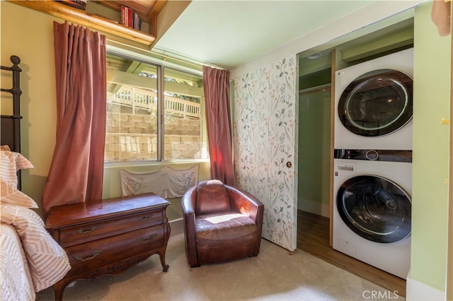 laundry room featuring stacked washer / drying machine and wood-type flooring