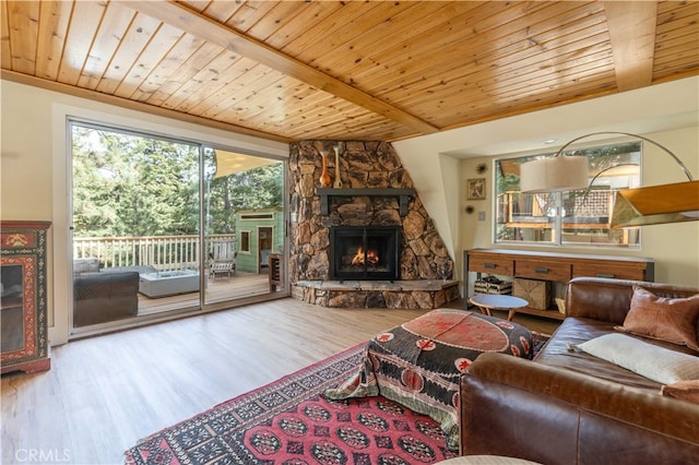 living room with a stone fireplace, wood-type flooring, beamed ceiling, and wooden ceiling