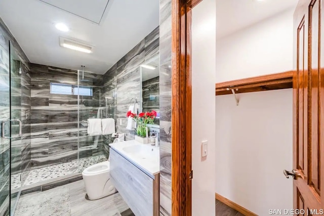 bathroom featuring a shower with door, vanity, hardwood / wood-style flooring, and toilet