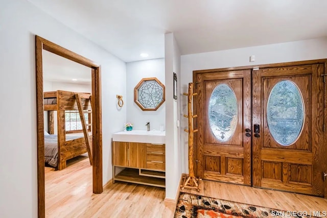 entrance foyer featuring light hardwood / wood-style flooring, french doors, and sink