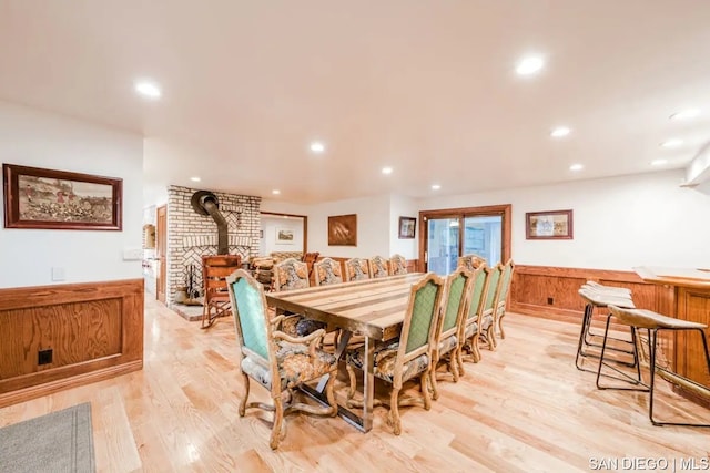 dining room with a wood stove and light hardwood / wood-style flooring