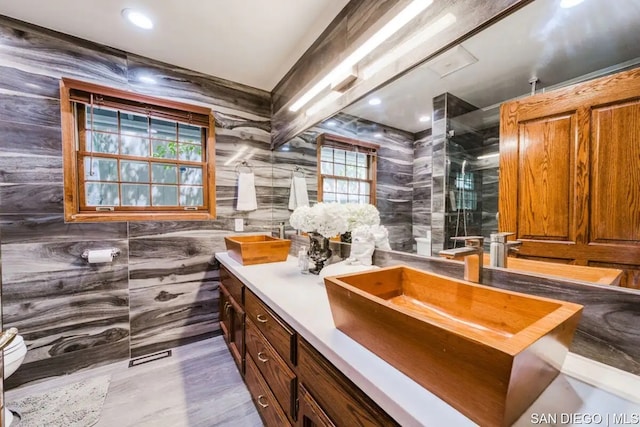 bathroom featuring tile walls, vanity, hardwood / wood-style flooring, and an enclosed shower