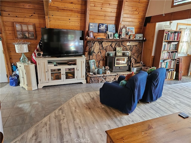 living room with wooden walls, lofted ceiling with beams, wood ceiling, and light hardwood / wood-style floors