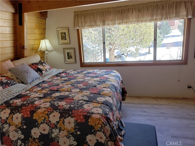 bedroom with wood-type flooring and wooden walls