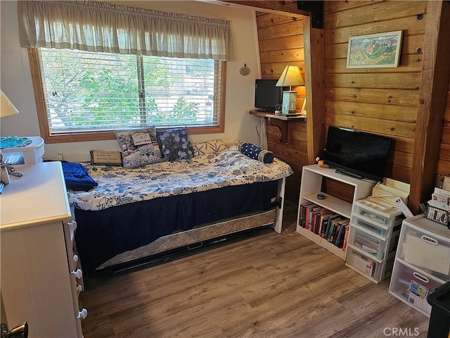 bedroom with multiple windows and hardwood / wood-style flooring