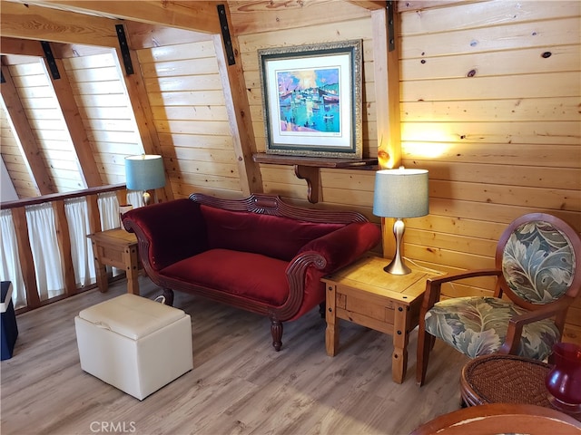 sitting room with light hardwood / wood-style flooring and wooden walls