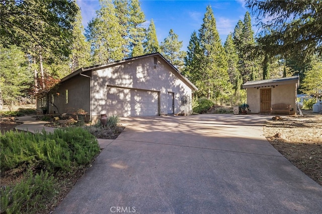 view of home's exterior with a garage and an outbuilding