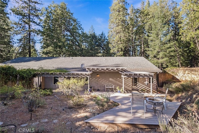 rear view of house featuring a deck and a fire pit