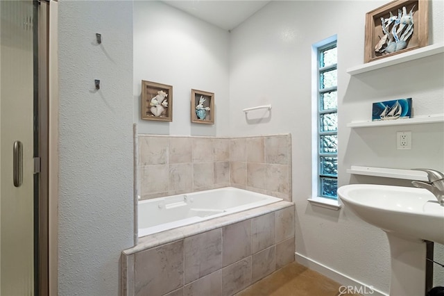 bathroom featuring sink and tiled bath