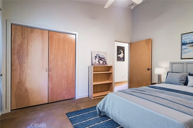 bedroom with concrete floors, ceiling fan, and a closet