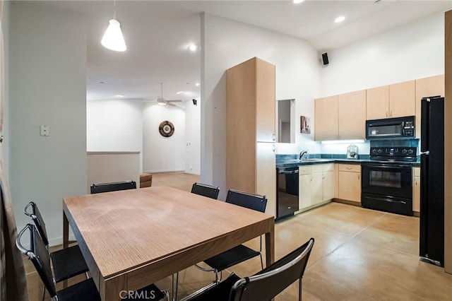 dining space featuring a towering ceiling, sink, and ceiling fan