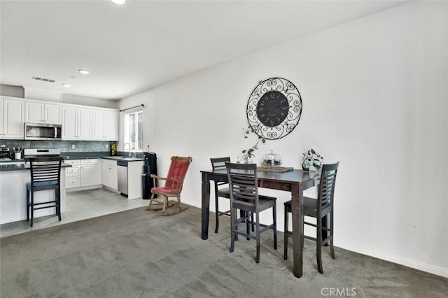 dining room with visible vents and light colored carpet