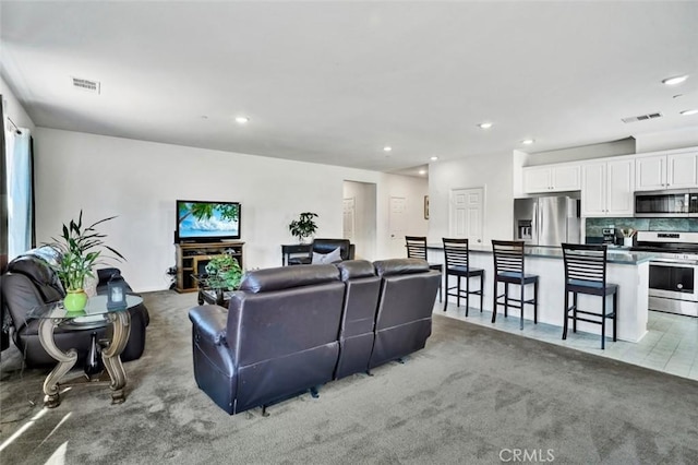 carpeted living room featuring visible vents and recessed lighting
