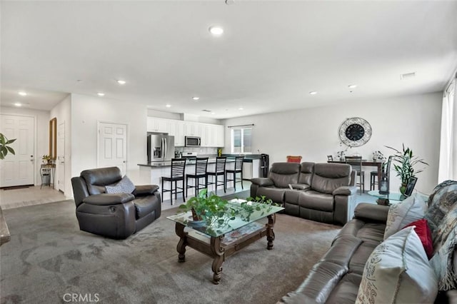 living area featuring carpet flooring and recessed lighting