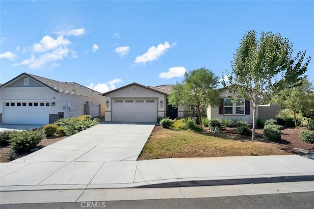 single story home with stucco siding, a garage, and concrete driveway