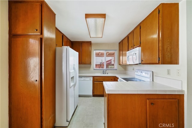 kitchen with kitchen peninsula, sink, and white appliances