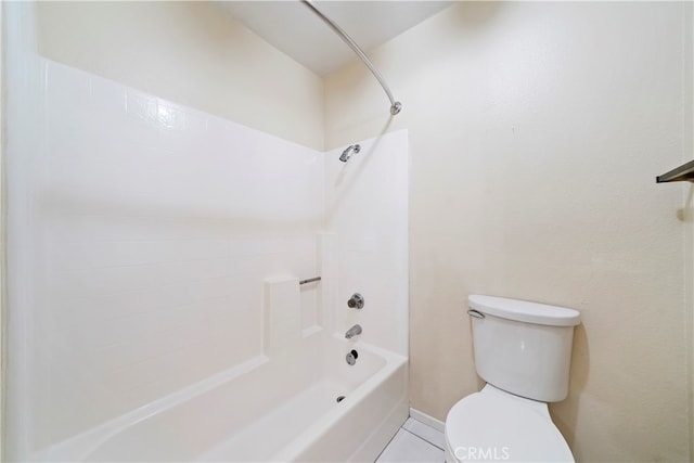 bathroom featuring bathing tub / shower combination, tile patterned flooring, and toilet