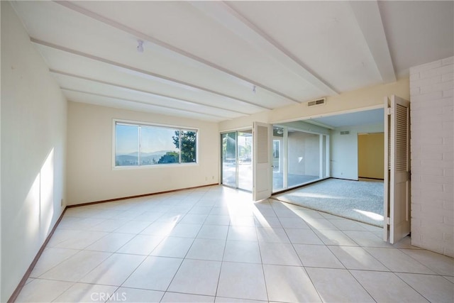 tiled empty room with beamed ceiling